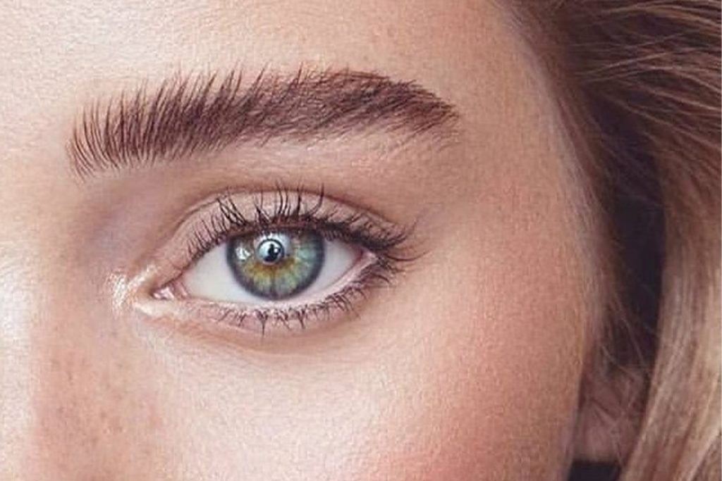 Kaş laminasyonu yaptırmış bir kadının yeşil sol gözü ile kaşlarının göründüğü bir fotoğraf kesiti