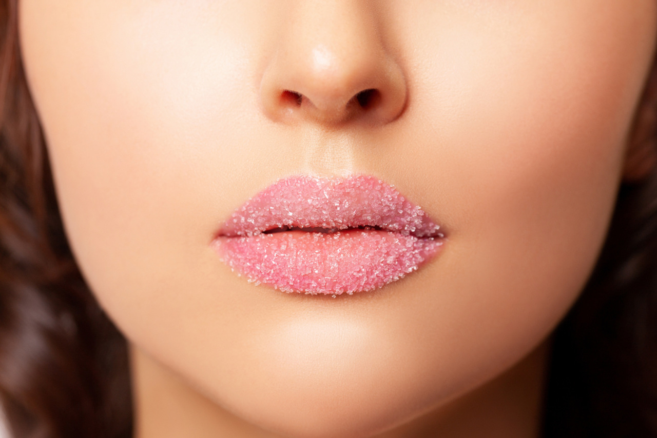 dudak bakımı için dudaklarına peeling malzemesi uygulayan kadın
